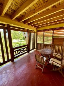 a screened in porch with a table and chairs at Trano Aloalo in Foulpointe +1 photo