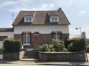 a brick house with a brown door and windows at Saint exupery in Offranville