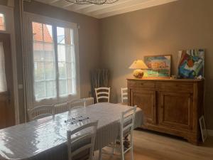 a dining room with a table and chairs and a window at Saint exupery in Offranville