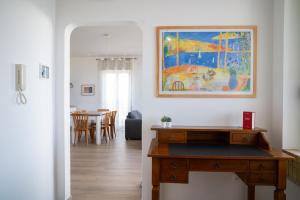 un soggiorno con tavolo e un dipinto sul muro di FRONTEMARE Suites a Bacoli