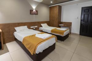 科钦Aryaas Residency Nettoor的一间酒店客房,房间内设有两张床