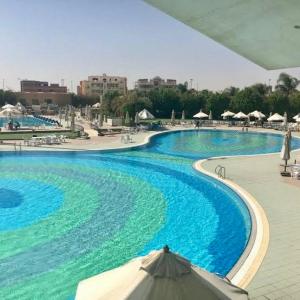 an overhead view of a swimming pool with an umbrella at Luxe Home in Madinaty in Madinaty