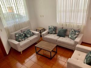 a living room with two couches and a coffee table at Yanahuara Habitacion Acogedora in Yanahuara