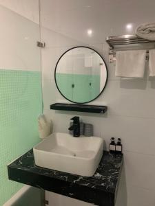 a bathroom with a sink and a mirror at Nhà Nghỉ Đảo Yến in Vụng Chùa