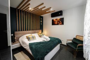a bedroom with a bed with a green blanket at Loft 150 m2 Jacuzzi, Sauna et Massage in Blagnac +27 photos