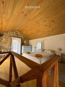 a bedroom with a large bed with wooden ceilings at Vista Verde Lodge in Vale de Cambra