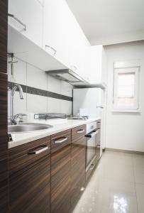 a kitchen with wooden cabinets and a sink at Nice Apartment in Gevgelija +2 photos