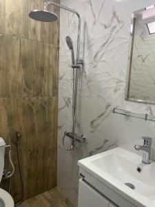 a bathroom with a shower and a sink at Стаи за гости Бела in Ahtopol