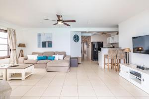 a living room with a couch and a tv at Bellevue Residence #7 - Oceanfront condo in Kralendijk
