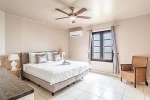 a bedroom with a bed and a ceiling fan at Bellevue Residence #7 - Oceanfront condo in Kralendijk +33 photos