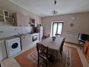 a kitchen with a table and a kitchen with a table and chairs at Obelisco Apartment Calascibetta in Calascibetta