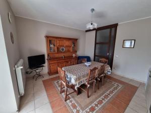 a dining room with a table and chairs and a television at Obelisco Apartment Calascibetta in Calascibetta