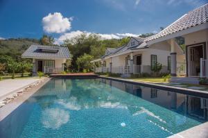 a swimming pool in front of a house at Suksompong Resort in Khao Lak