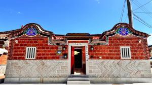 金湖镇木馬丑盒子古厝民宿 Troy Droll Bin的红砖建筑,有红门