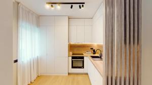 a kitchen with white cabinets and a sink at Casa de vacanta Cris 2 in Băile Olăneşti