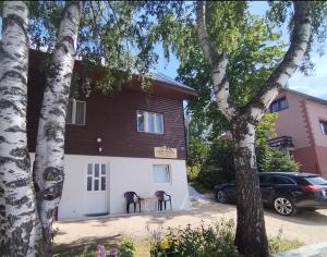 a house with two chairs and a table in front of it at Mountain Life in Žabljak