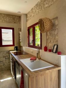 una cucina con un lavello e un piano di lavoro di La petite Maison en Normandie a Muids Altre 48 foto