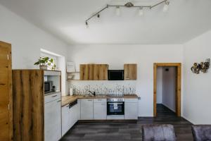 a kitchen with white appliances and wooden cabinets at Jordys Ferienapartment in Rechnitz