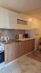 eine Küche mit weißen Geräten und Holzschränken in der Unterkunft Apartment Anis in Mostar