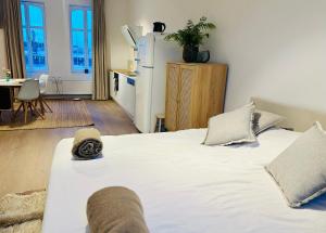 a bedroom with a white bed and a refrigerator at Suite kaai 24 in Nieuwpoort