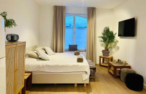 a bedroom with a bed and a large window at Suite kaai 24 in Nieuwpoort