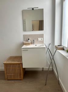 a bathroom with a white sink and a mirror at Suite kaai 24 in Nieuwpoort