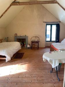 a bedroom with a bed and a table in a room at L'Adventice in Riec-sur-Bélon