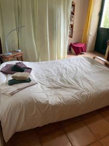 a white bed with two towels on top of it at L'Adventice in Riec-sur-Bélon