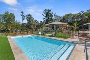 a swimming pool in a yard with a house at King Safari Tent 5 in Nelly Bay