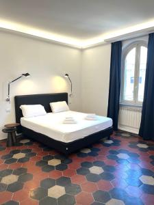 a bedroom with a bed on a checkered floor at Inn Urbe Colosseo in Rome
