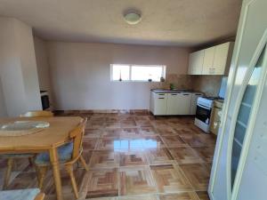 a kitchen with a table and a wooden floor at Carlitos in Gospić +14 photos