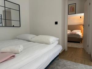 een slaapkamer met een bed met witte lakens en een spiegel bij Apartman A in the heart of Ferhadija - Parking available in Sarajevo