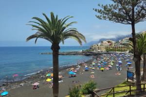 una playa con un montón de gente con sombrillas en OBSIDIAN Mirador del Oceano, en Puerto de Santiago