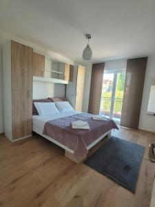 ein Schlafzimmer mit einem großen Bett und einem großen Fenster in der Unterkunft N&M apartments in Vodice