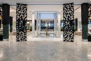 a lobby with a large glass door and pillars at One Resort Premium Hammamet in Hammamet Nord