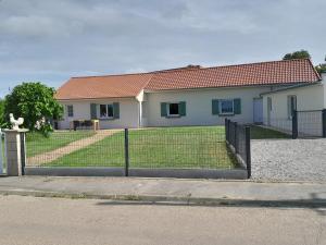 una casa con una recinzione di fronte a un cortile di Chez Paulette a Halinghen