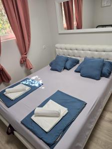 a bed with blue and white pillows on it at Amelie & Sea - Ground Floor Penthouse with 2 Terraces, Green Views, Sleeps 9 in Vir