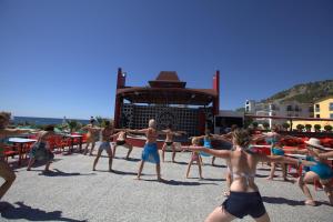 a group of people dancing on the beach at Aleria Belport Beach Hotel in Beldibi
