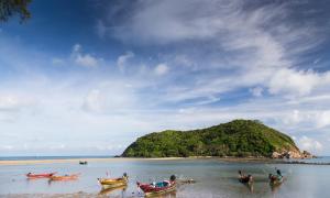 a group of boats in the water near an island at Maehaad Bay Resort - SHA Plus in Mae Haad