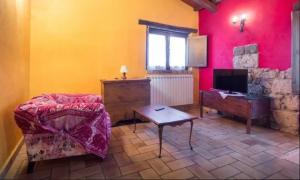 sala de estar con sofá, mesa y TV en B&B La Terrazza, en Civitella dʼAgliano