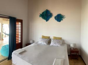 a bedroom with a large white bed with two pillows at Casa do Capitao in Guajiru