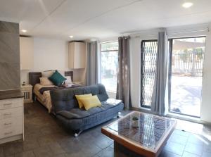 Una sala de estar con un sofá y una mesa de café. en Atterbury self catering studios, en Pretoria