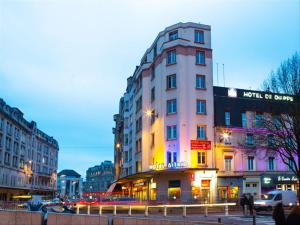 a tall white building in a city at night at Hôtel Astrid in Rouen