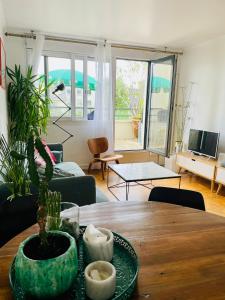 a living room with a table with a plant on it at 2 BEDROOMS & TERRACE with BBQ COURBEVOIE PARIS in Courbevoie