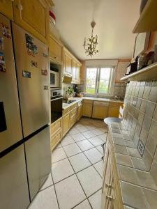 a kitchen with wooden cabinets and a refrigerator at 2 BEDROOMS & TERRACE with BBQ COURBEVOIE PARIS in Courbevoie +12 photos