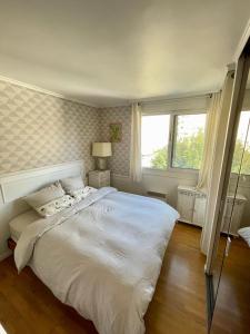 a bedroom with a large white bed and a window at 2 BEDROOMS & TERRACE with BBQ COURBEVOIE PARIS in Courbevoie