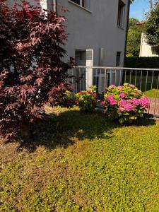 a house with flowers in front of a fence at Casette Airport AGATA in Seriate