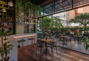 a bar with tables and chairs in a restaurant at VPV Suites in Medellín