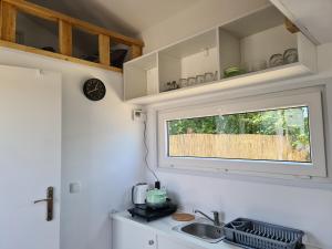 a kitchen with a sink and a window at Srebrna Riwiera Kadyny in Kadyny