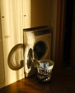 a washing machine sitting next to a laundry basket at Le Port Boutique Apart Hotel in Batumi
